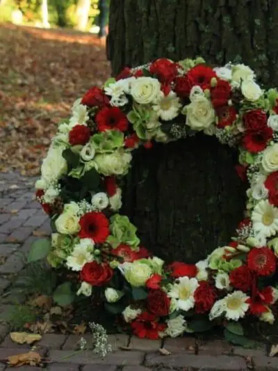 Sympathy wreath near a tree dartford florist