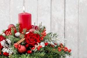 Christmas decoration with candle, red roses, fir, brunia and cinnamon sticks dartford florist