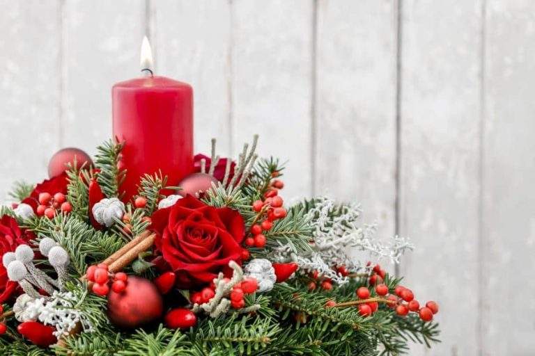 Christmas decoration with candle, red roses, fir, brunia and cinnamon sticks dartford florist