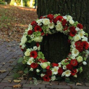 Sympathy wreath near a tree dartford florist