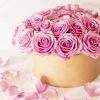 Beautiful floral bouquet with pink roses in a box on a pink background