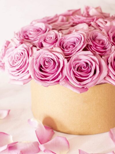 Beautiful floral bouquet with pink roses in a box on a pink background